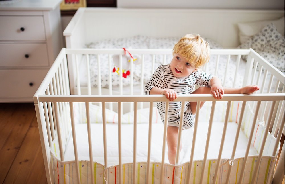 Child climbing higher up the ladder, with safe landing surface below